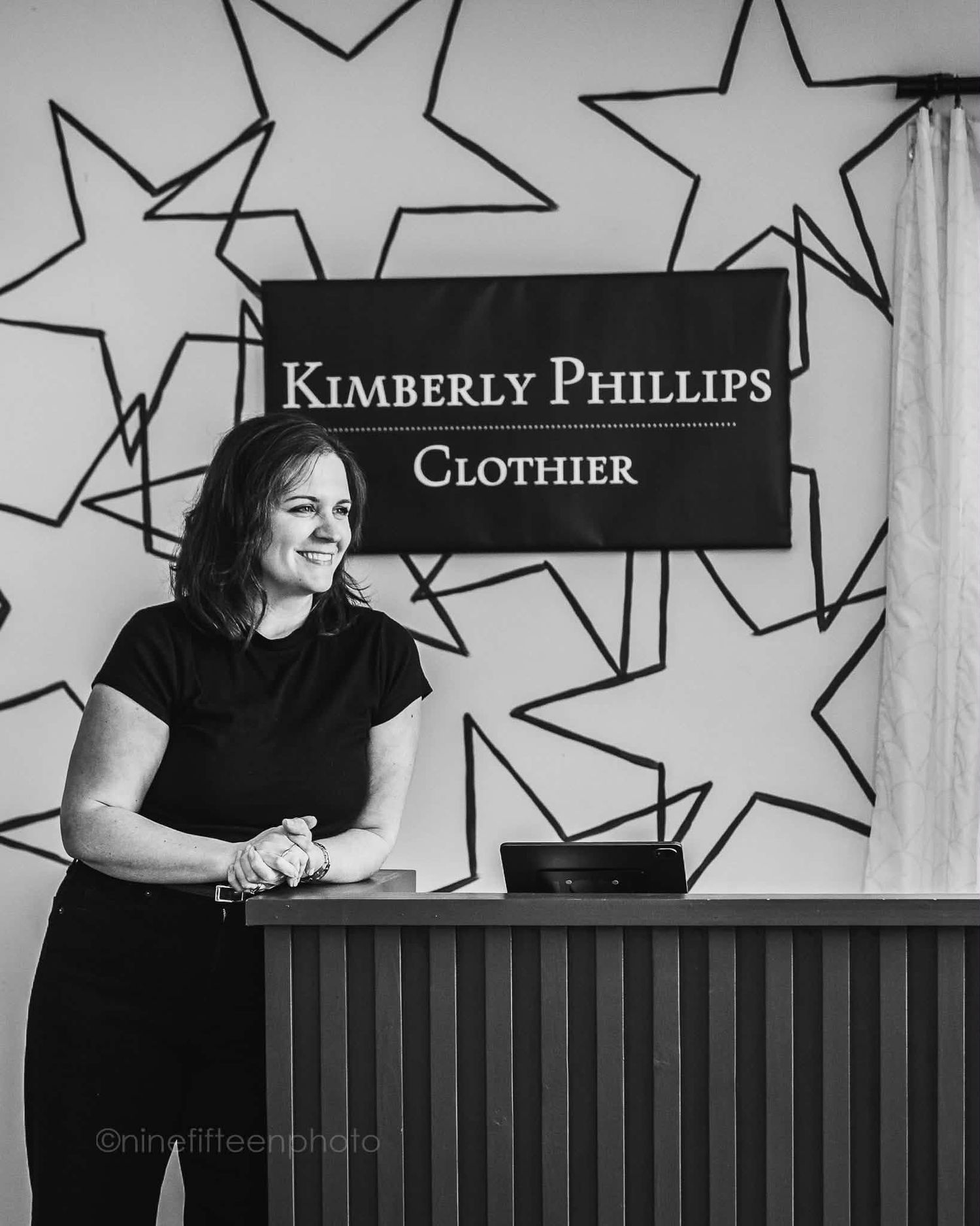 Black and white photo of woman at counter in Kimberly Phillips Clothier bridal boutique.