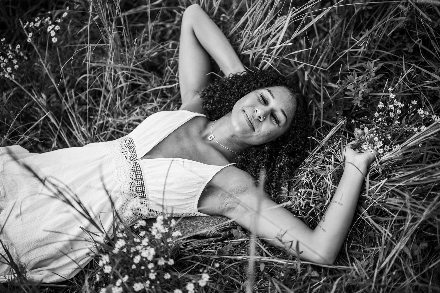 Black and white senior portrait of Bella lying in field during Brandenburg KY photo session by ninefifteenphoto