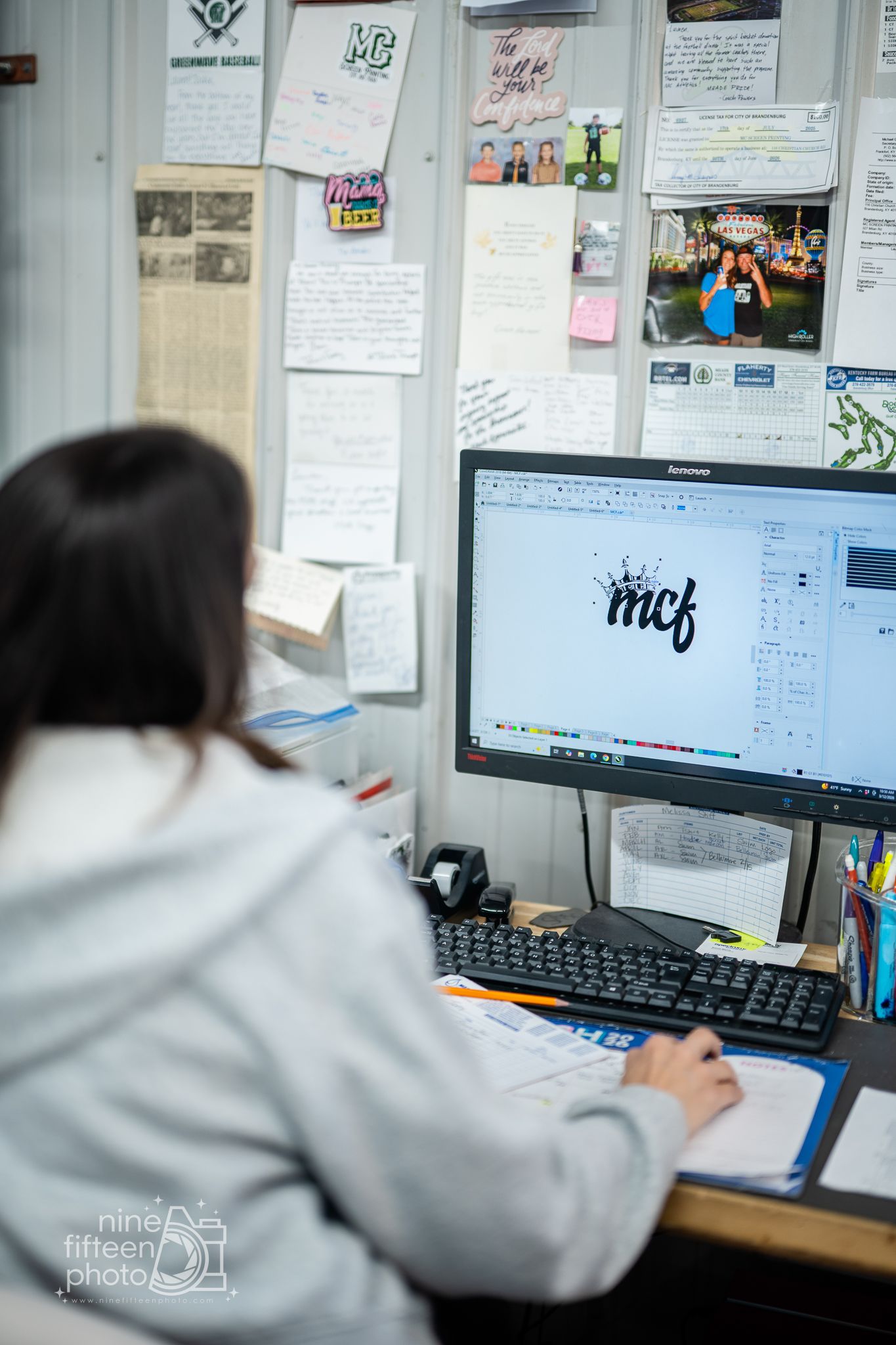 Graphic designer working on MCF logo design using vector software on a desktop computer.
