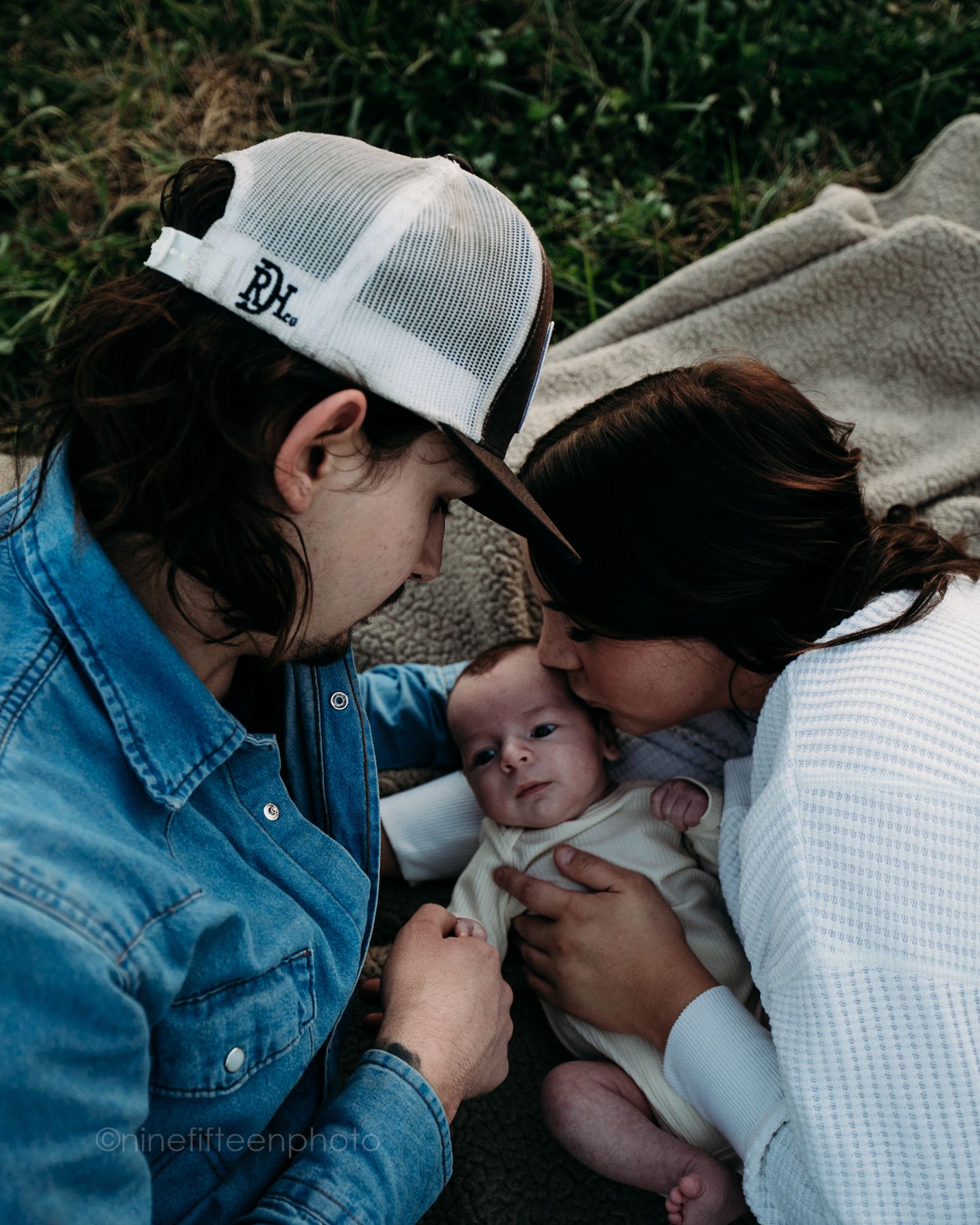 Custer KY newborn lifestyle photo of Kaylin and Caleb with their baby Devin, captured by ninefifteenphoto in rustic golden light.