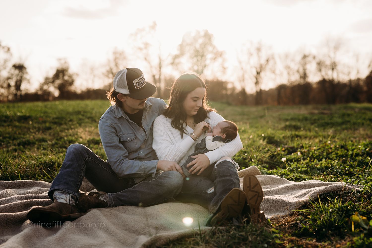 Custer KY newborn lifestyle photo of Kaylin and Caleb with their baby Devin, captured by ninefifteenphoto in rustic golden light.