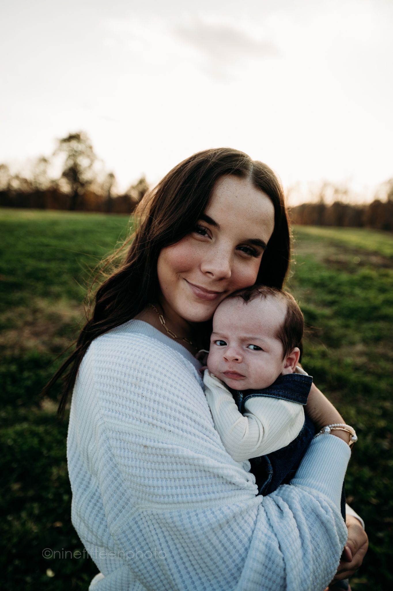 Custer KY newborn lifestyle photo of Kaylin and Caleb with their baby Devin, captured by ninefifteenphoto in rustic golden light.