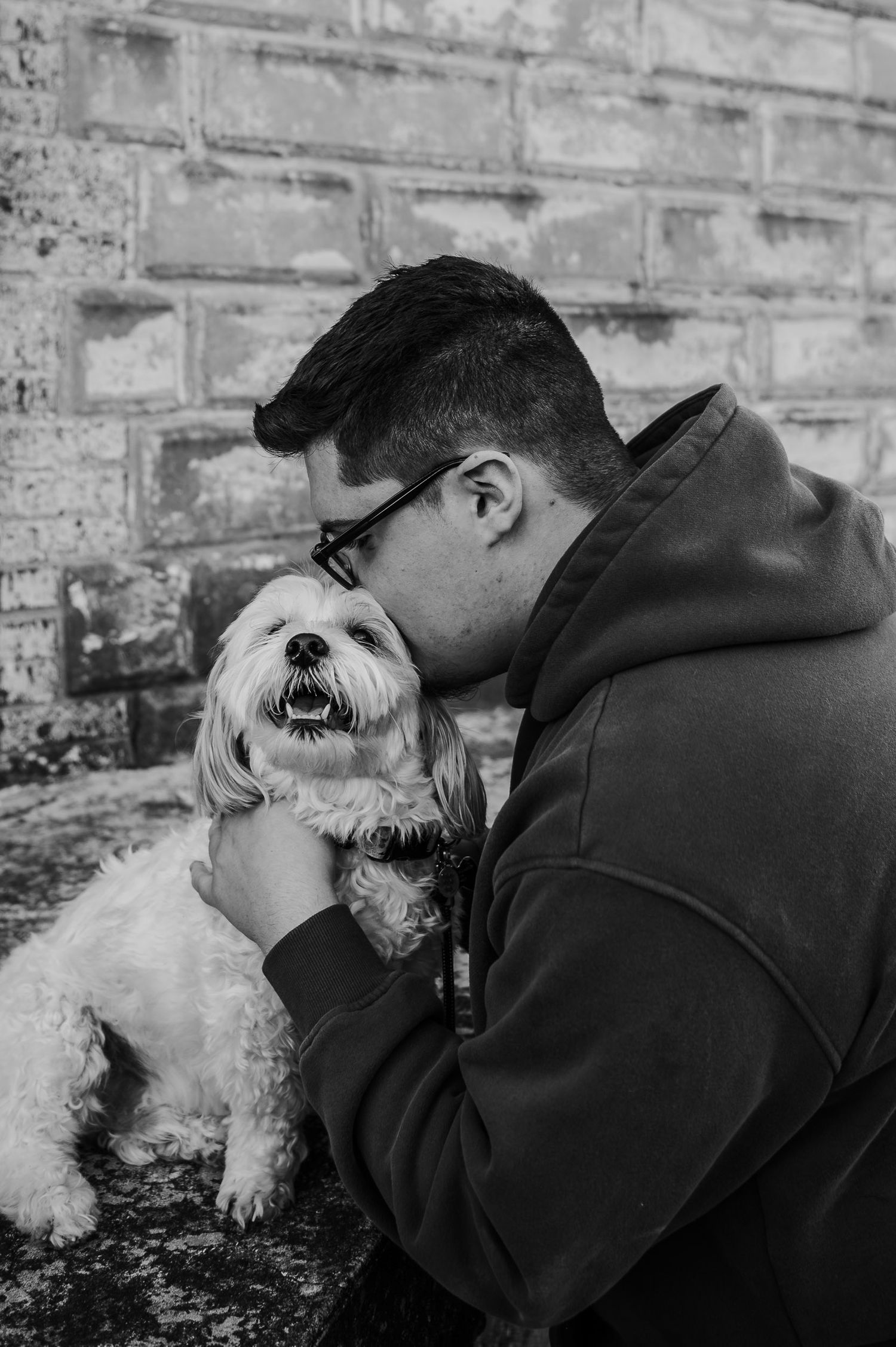 Black and white senior photo of Luca hugging his family dog during his Brandenburg KY photo session.