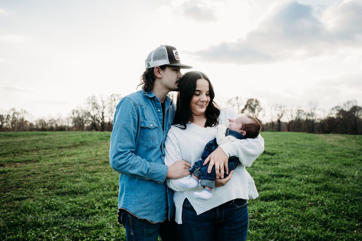 Custer KY newborn lifestyle photo of Kaylin and Caleb with their baby Devin, captured by ninefifteenphoto in rustic golden light.