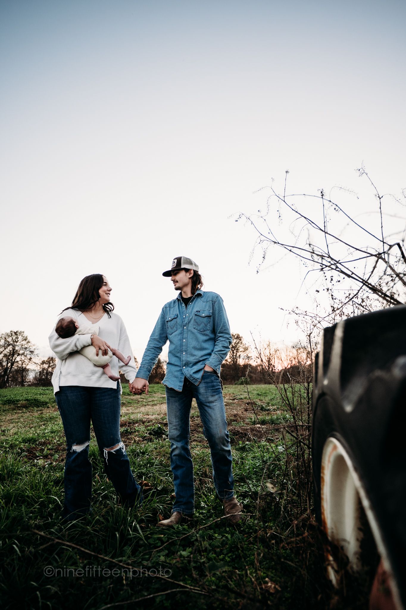 Custer KY newborn lifestyle photo of Kaylin and Caleb with their baby Devin, captured by ninefifteenphoto in rustic golden light.