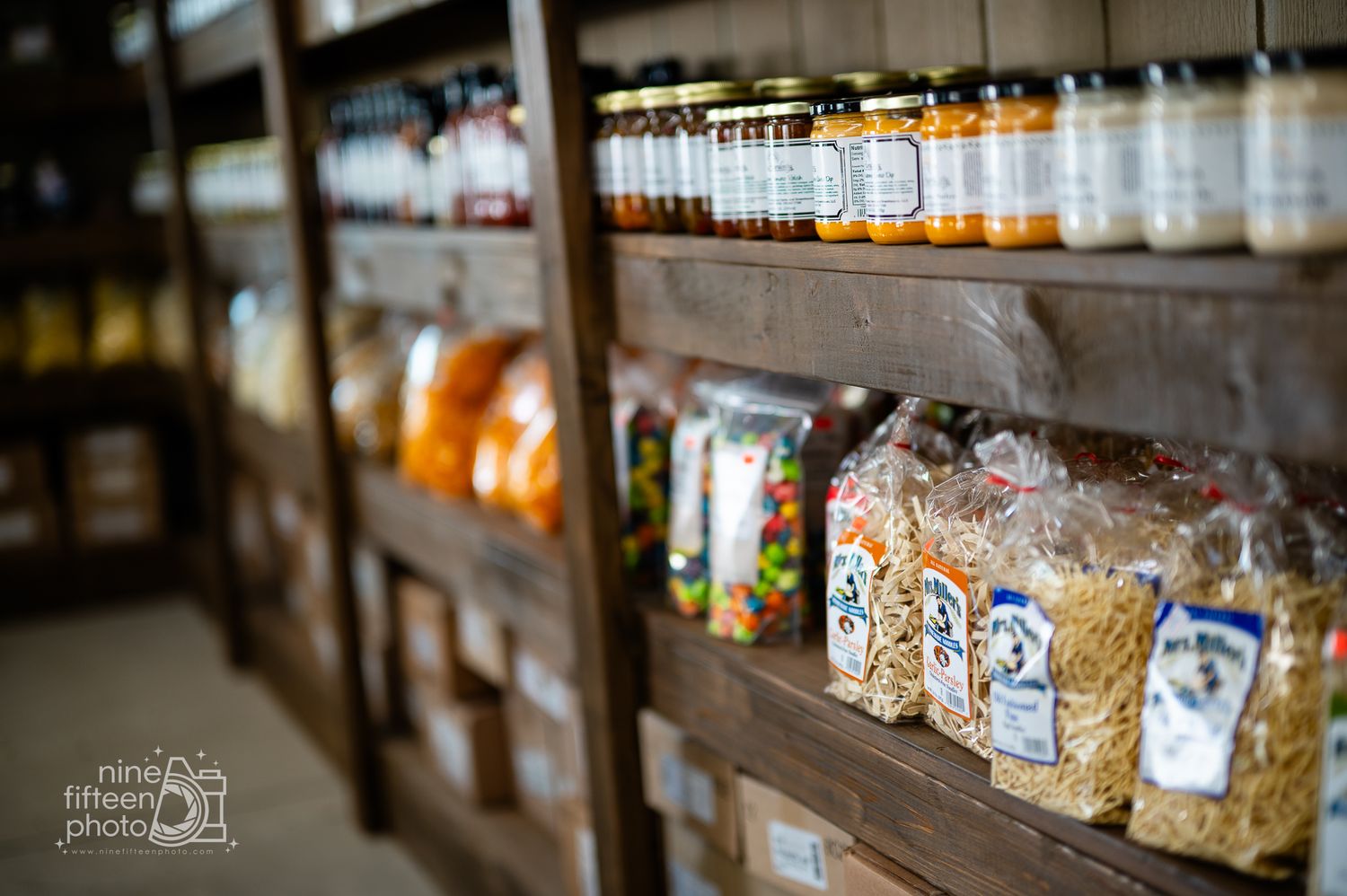 Rustic wooden shelves filled with jams, candy, and local goods inside the farm market at Hardesty Farms & Greenhouses.