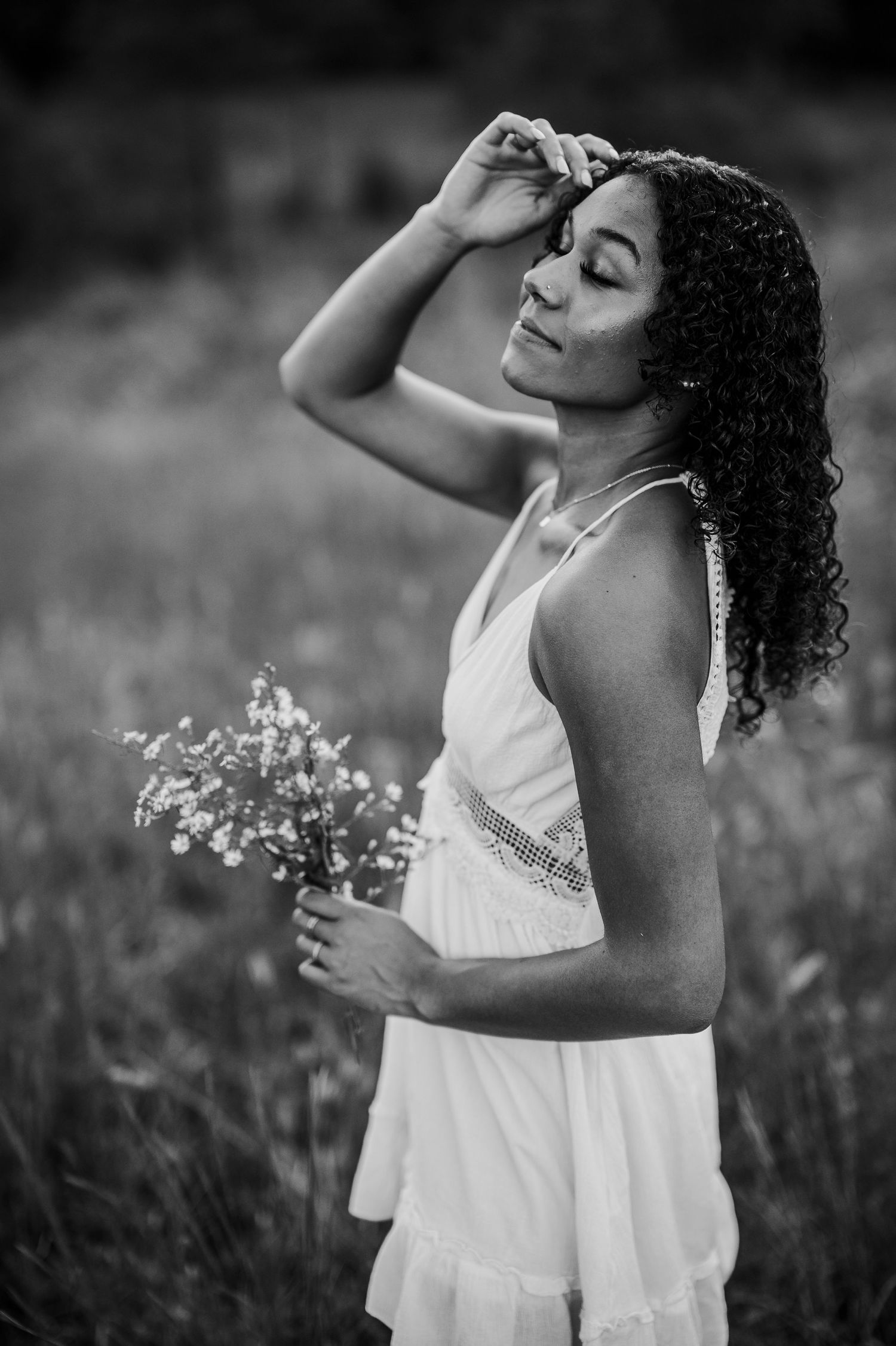 Bella holding wildflowers in Brandenburg KY field during outdoor senior photos by ninefifteenphoto