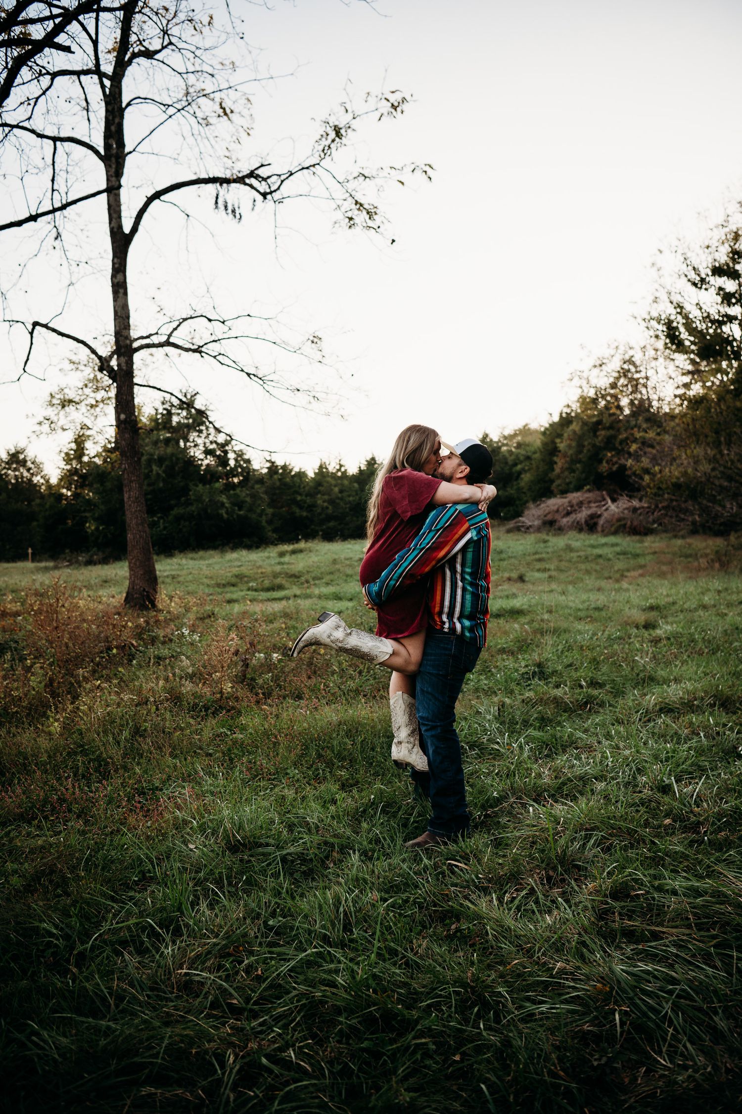 Mother and daughter hugging in open field surrounded by autumn trees in Guston Kentucky