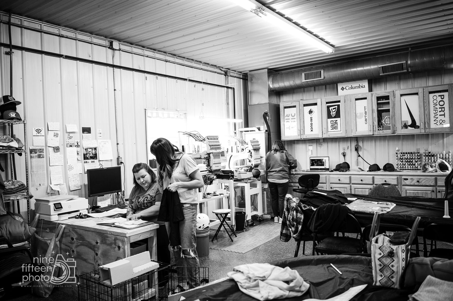 Black and white photo of busy workers inside MC Screen Printing apparel shop in Brandenburg Kentucky.