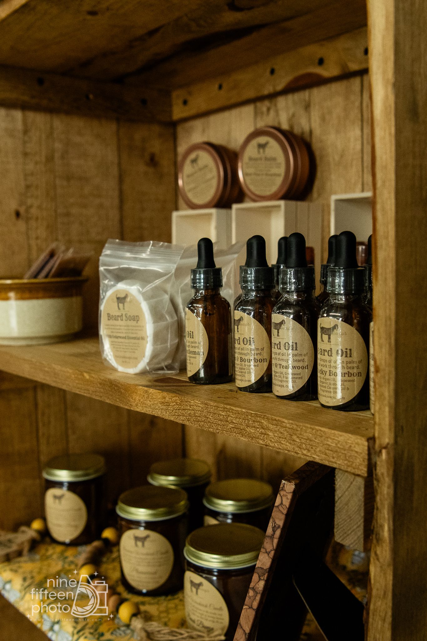 Rustic wooden shelves with handcrafted beard oils, soaps, and jars inside Hardesty Farms boutique market.