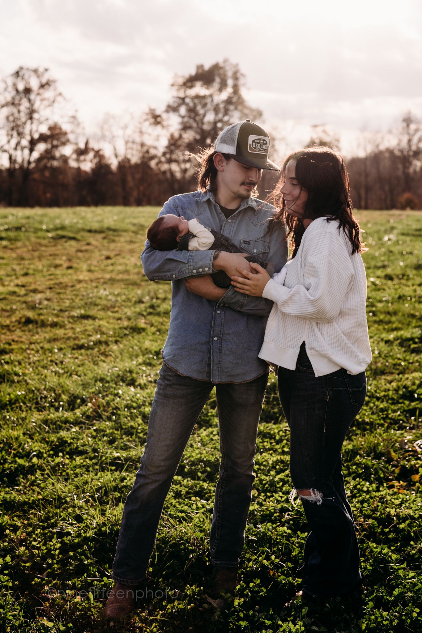 Custer KY newborn lifestyle photo of Kaylin and Caleb with their baby Devin, captured by ninefifteenphoto in rustic golden light.