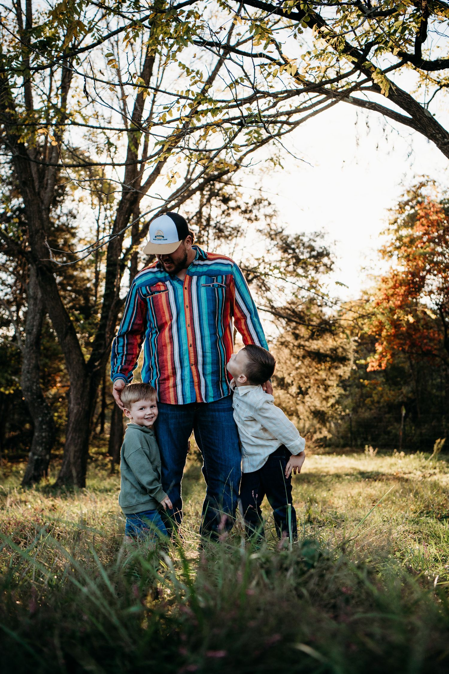 Father holding child while walking through field in Guston Kentucky at golden hour