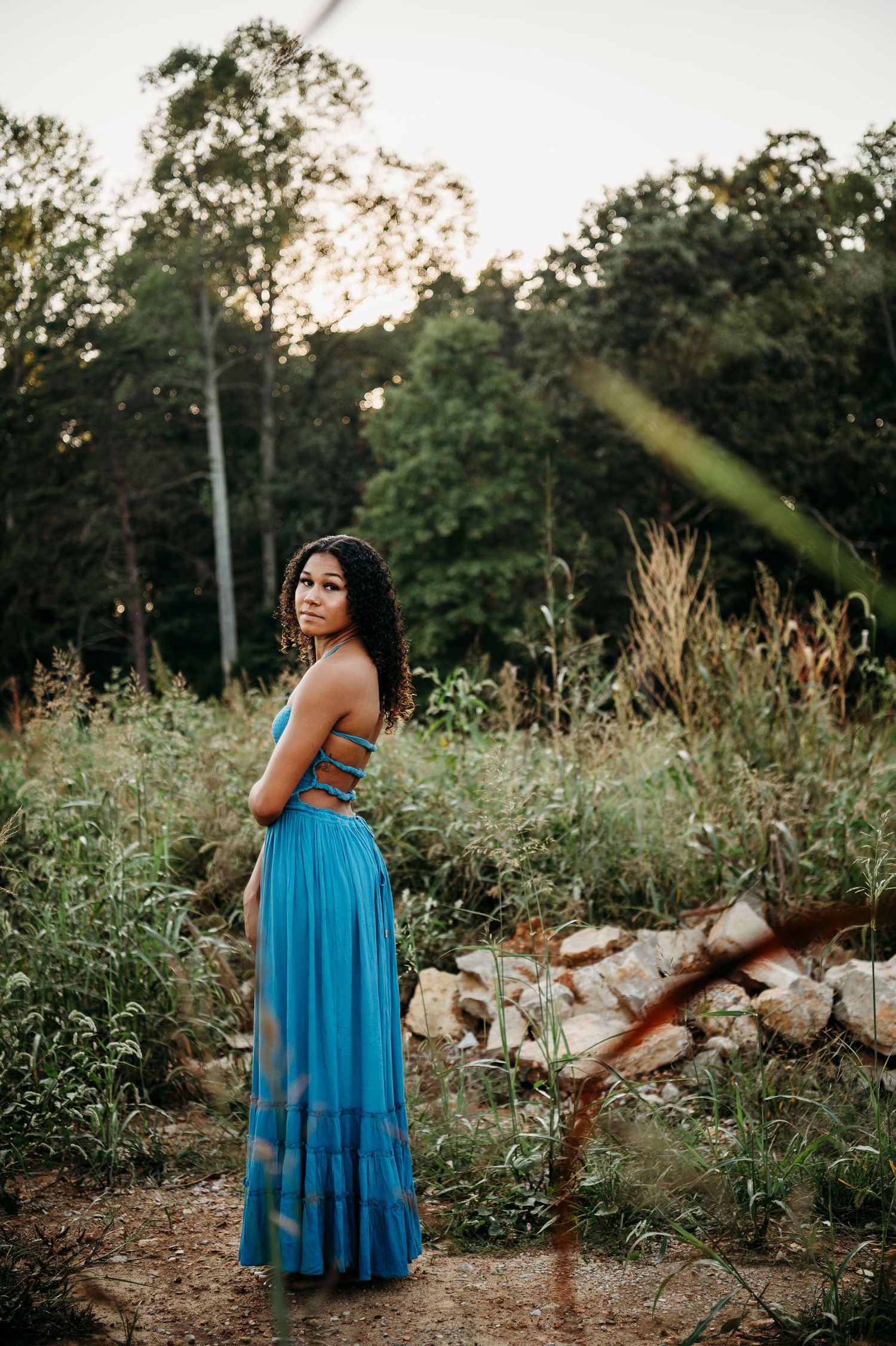Senior photo of Bella smiling in blue dress during Brandenburg Kentucky sunset session by ninefifteenphoto