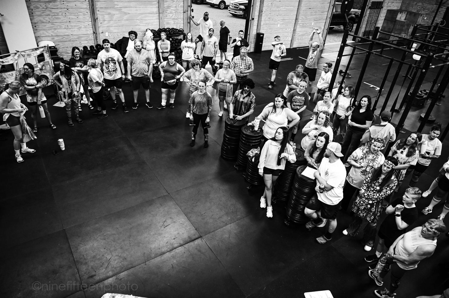 Black and white overhead view of large group gathered in a crossfit gym facility.