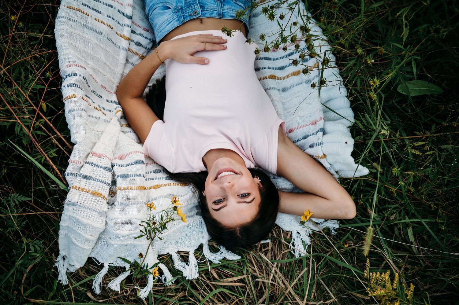 Emily laying on a patterned blanket during her golden hour senior session in Brandenburg KY with ninefifteenphoto.