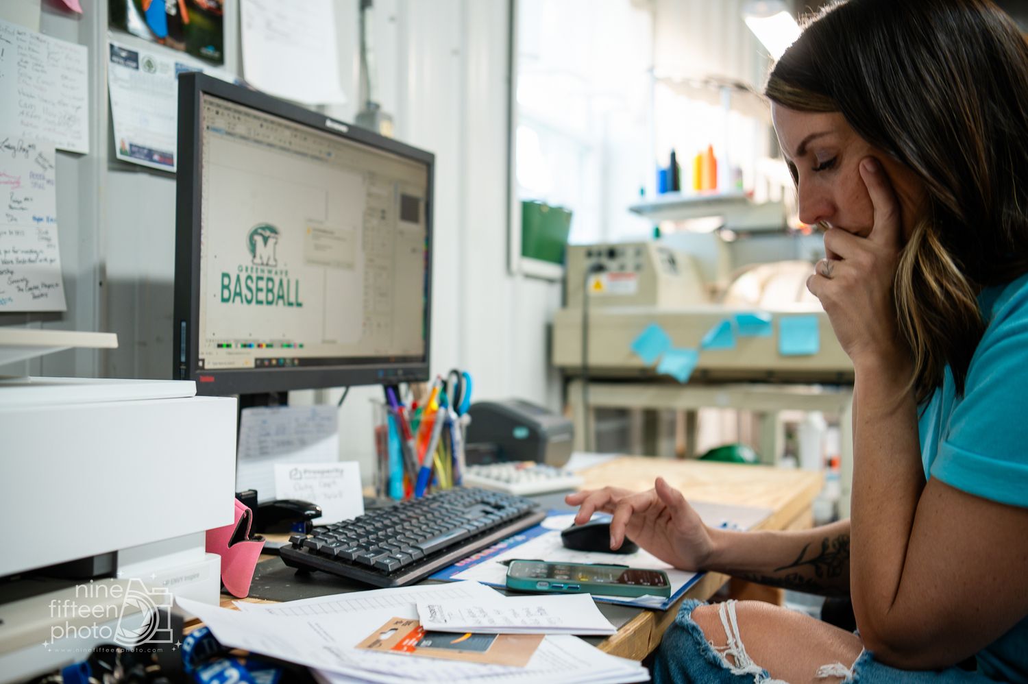 Woman reviewing baseball team logo designs at MC Screen Printing in Brandenburg Kentucky by ninefifteenphoto.