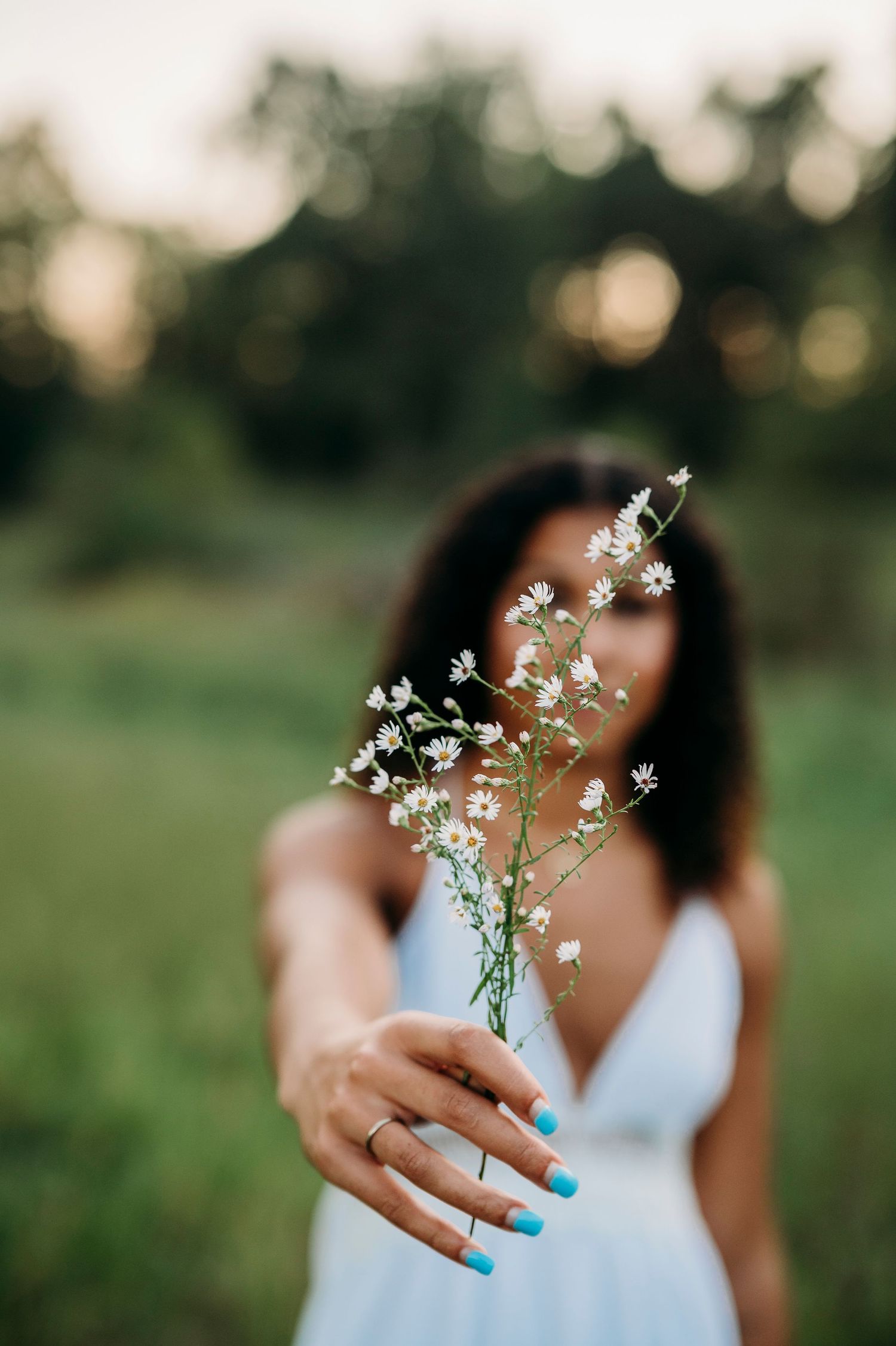 Bella holding wildflowers in Brandenburg KY field during outdoor senior photos by ninefifteenphoto