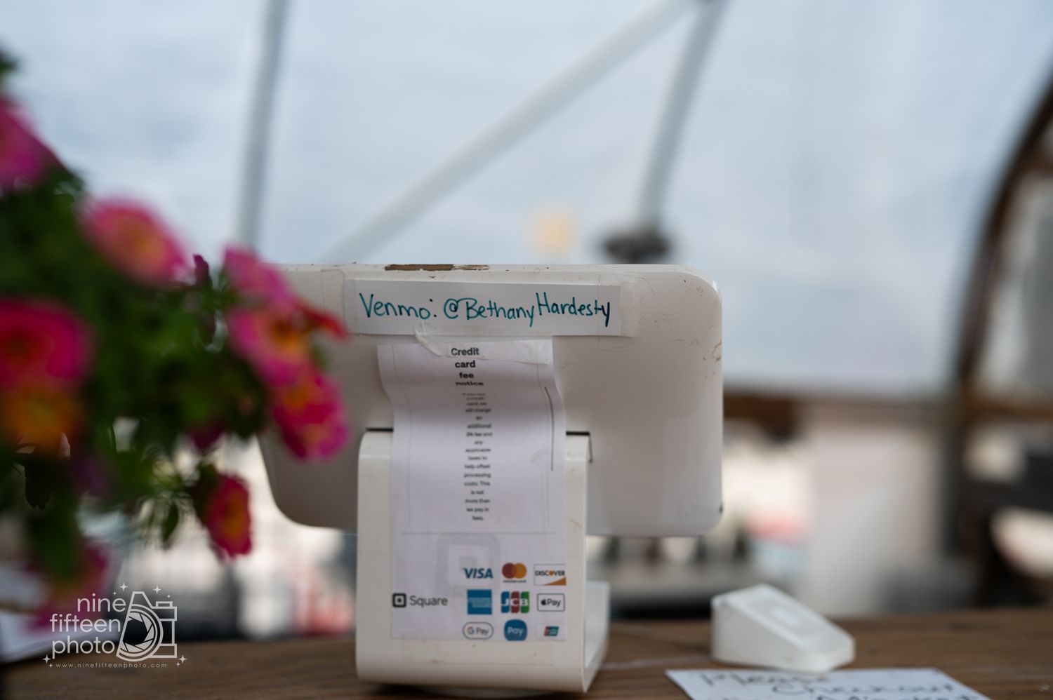 Point of sale terminal with receipt printer on wooden checkout counter inside Hardesty Farms farm market.