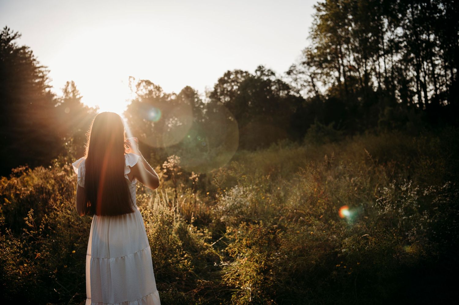 Emily walking through a golden field in Brandenburg KY during her senior photo session with ninefifteenphoto.