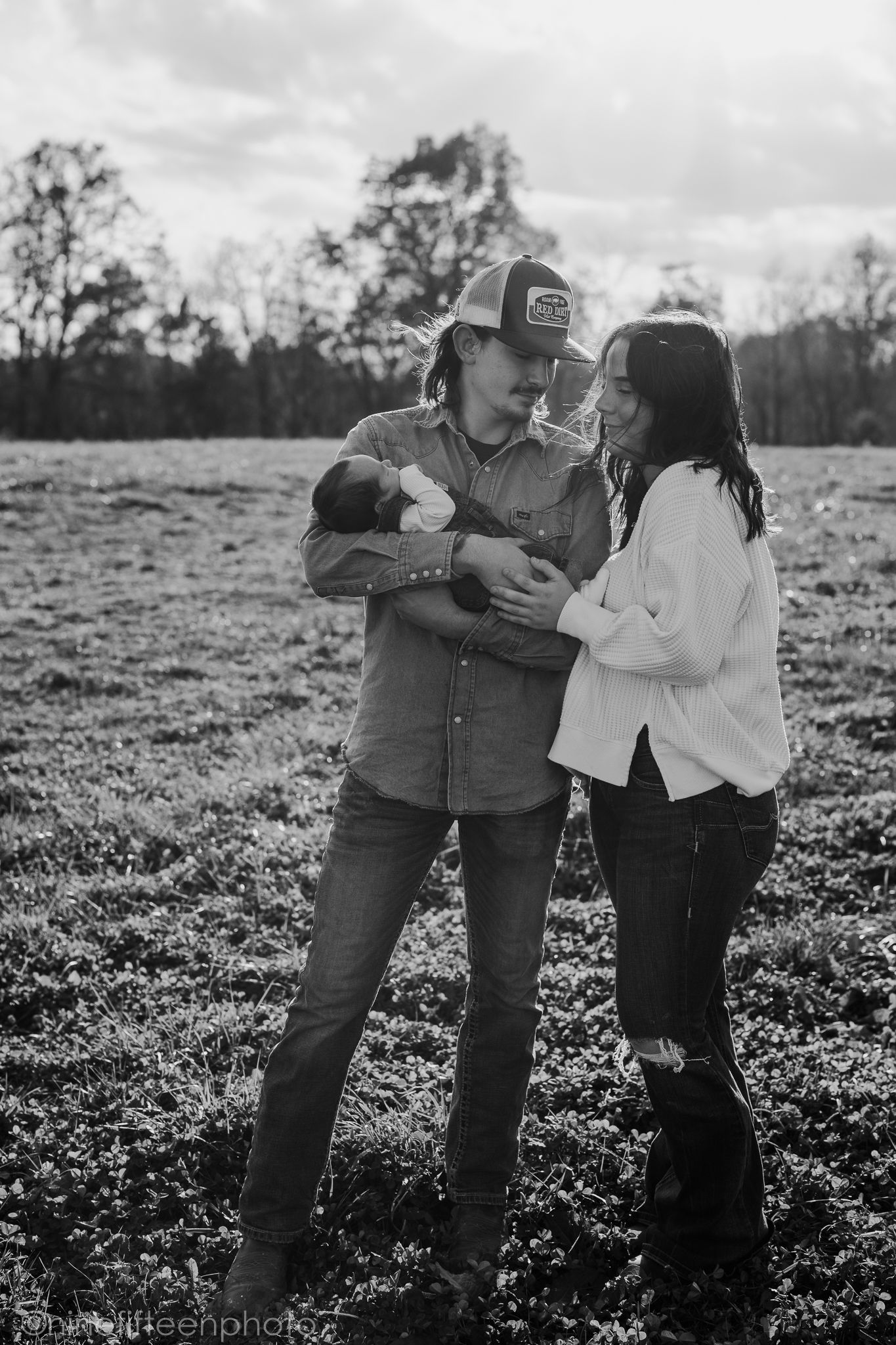 Custer KY newborn lifestyle photo of Kaylin and Caleb with their baby Devin, captured by ninefifteenphoto in rustic golden light.