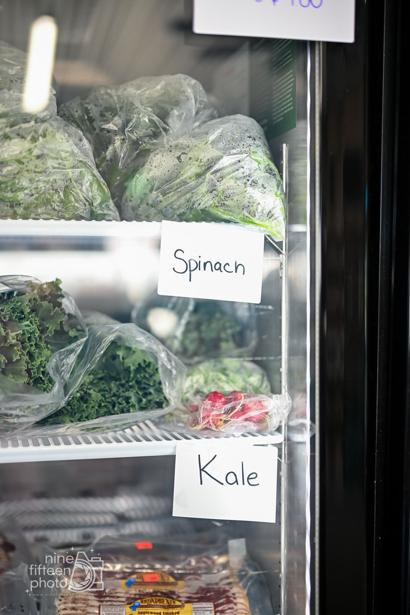 Fresh spinach and kale stocked inside the farm market cooler at Hardesty Farms & Greenhouses.