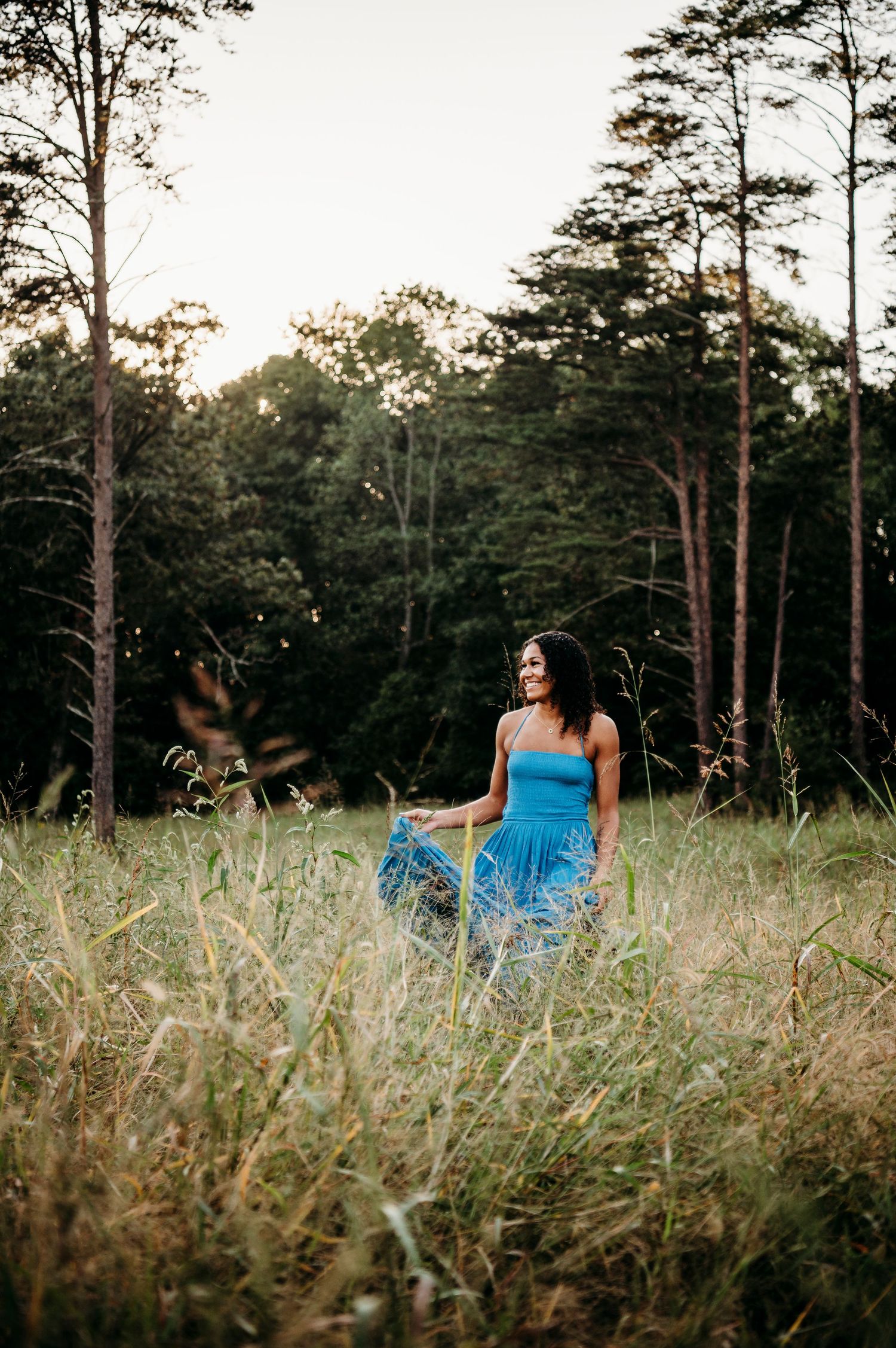 Bella standing in tall grass at sunset during Brandenburg KY country senior session by ninefifteenphoto