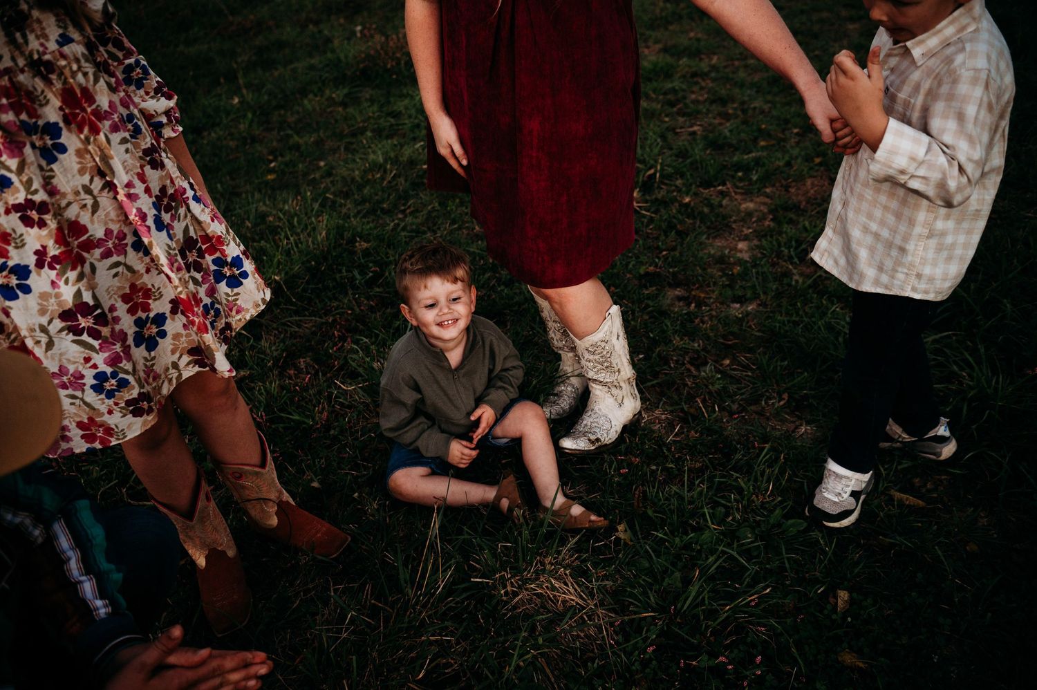 Children playing and laughing in tall grass during family session in Guston Kentucky