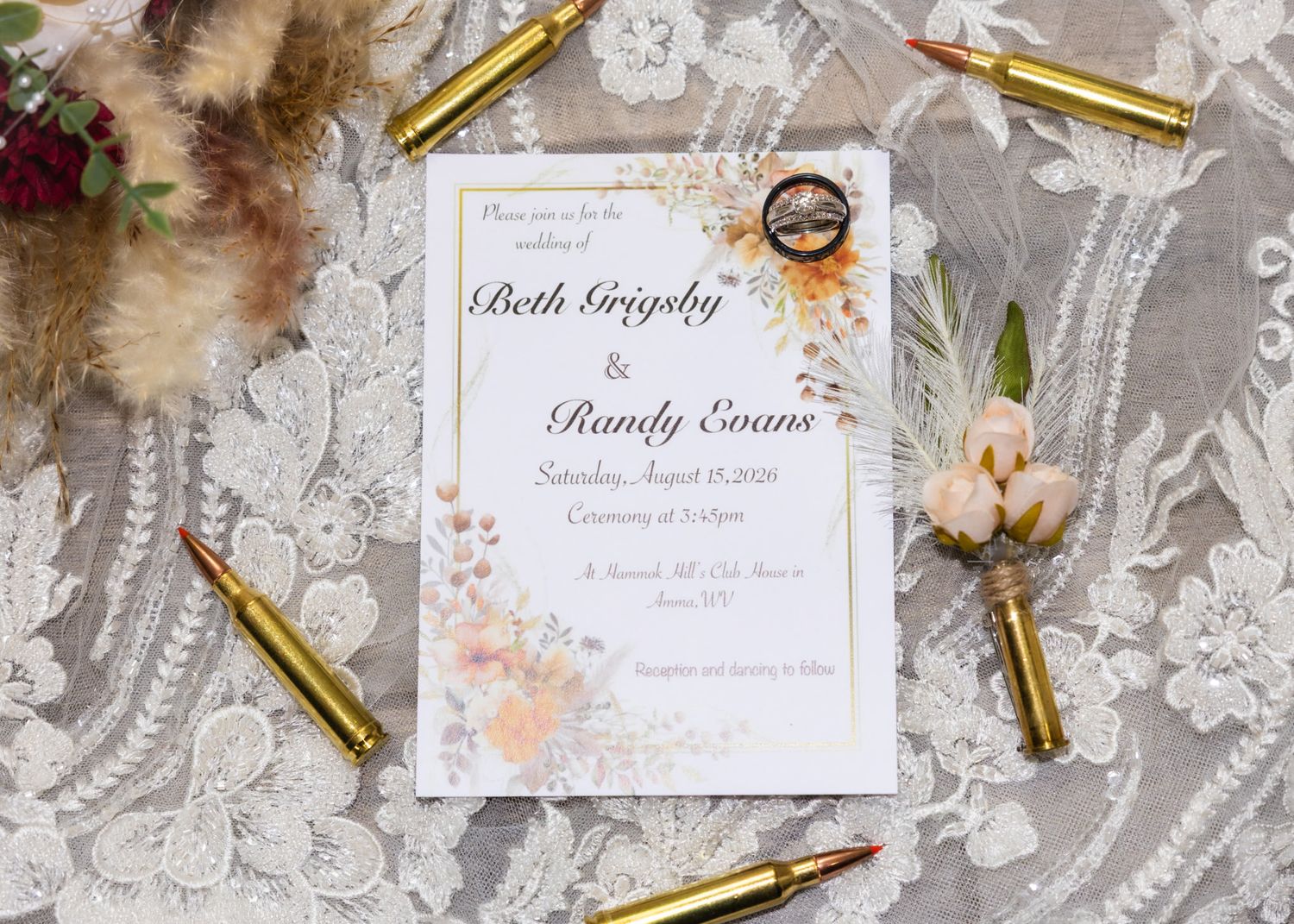 Elegant wedding invitation for Beth Grigsby and Randy Evans displayed with gold bullet casings and a floral boutonniere.