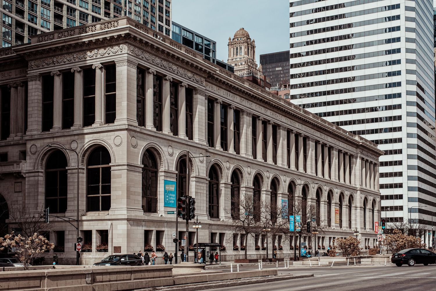 The historic Chicago Cultural Center building with ornate arched windows along a busy city street.
