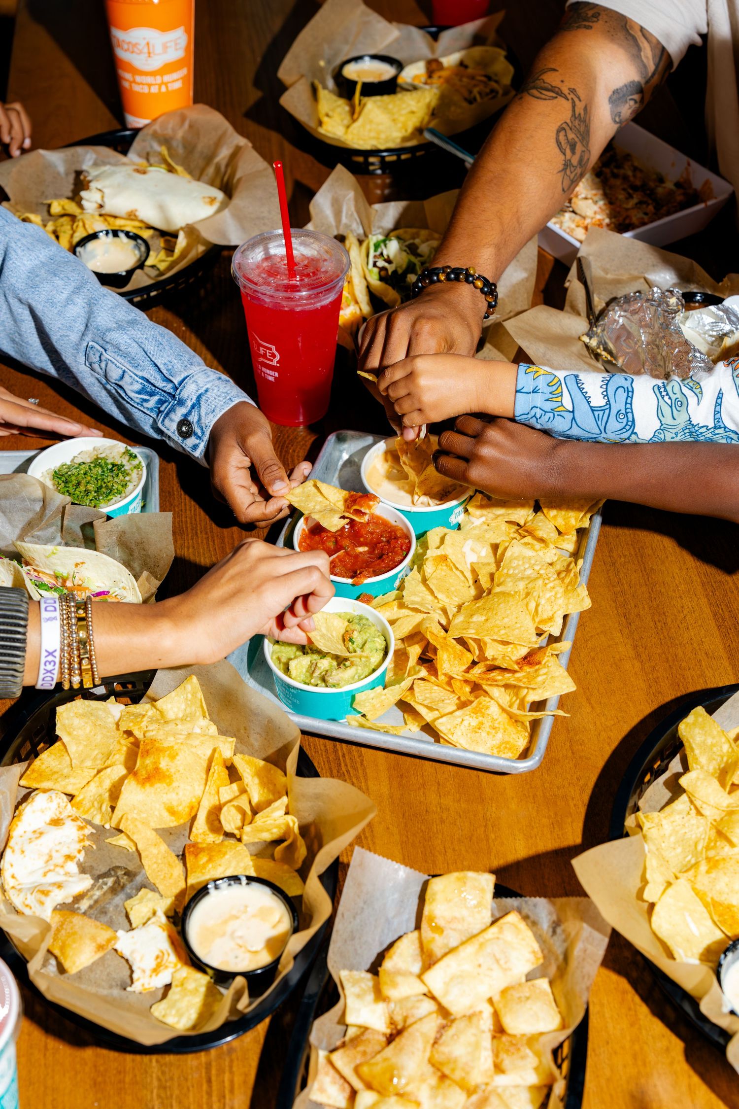People sharing nachos and drinks at a casual restaurant table.
