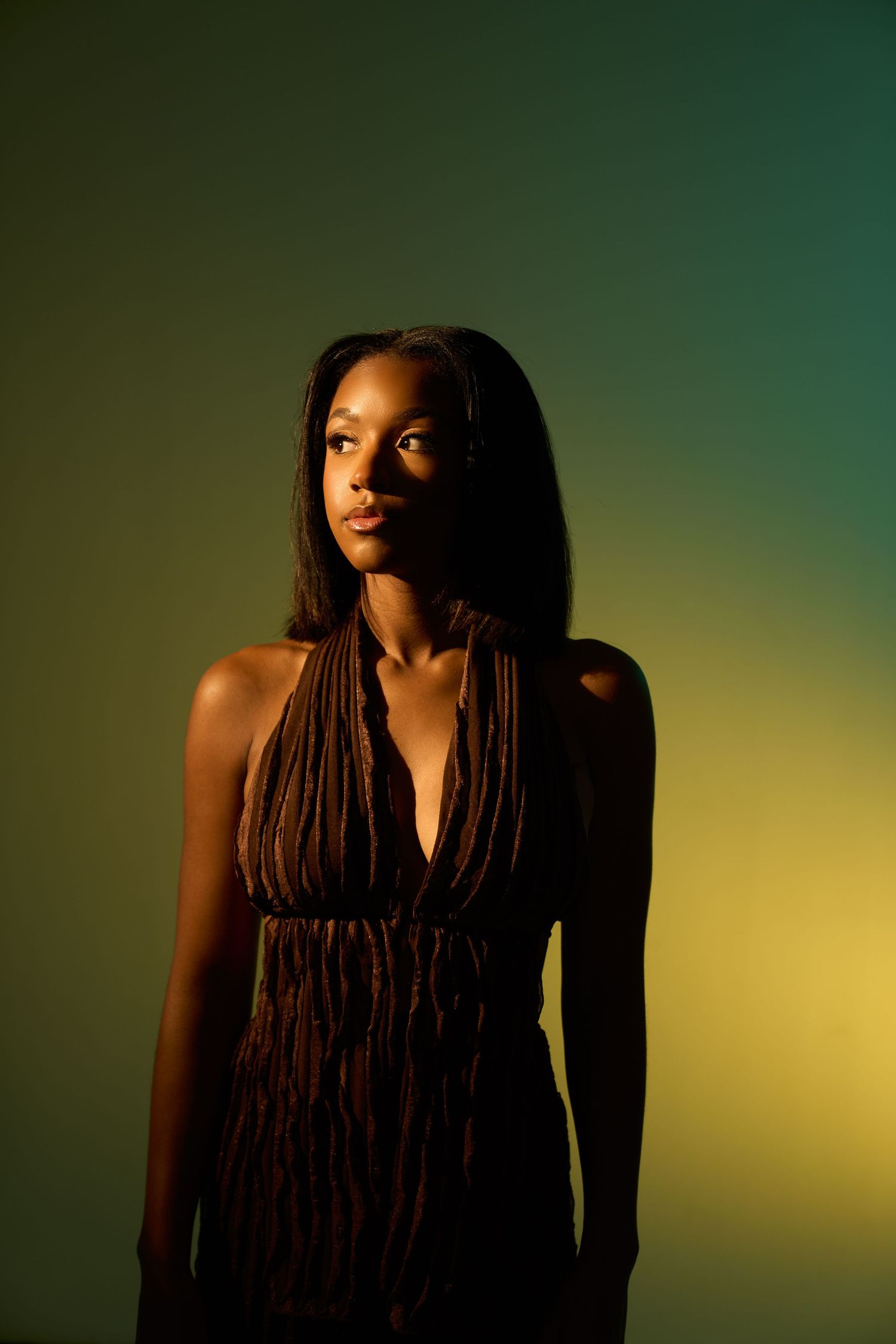 Dramatic portrait series with long braids against dark emerald and gold gradient.