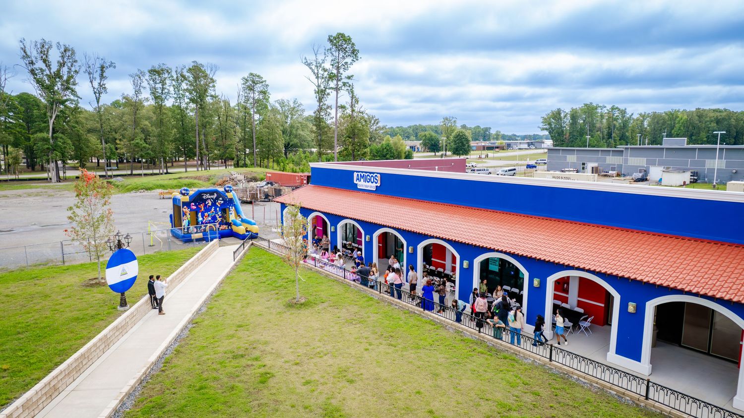 Modern retail building with bright blue and red exterior features arched doorways and walkways.