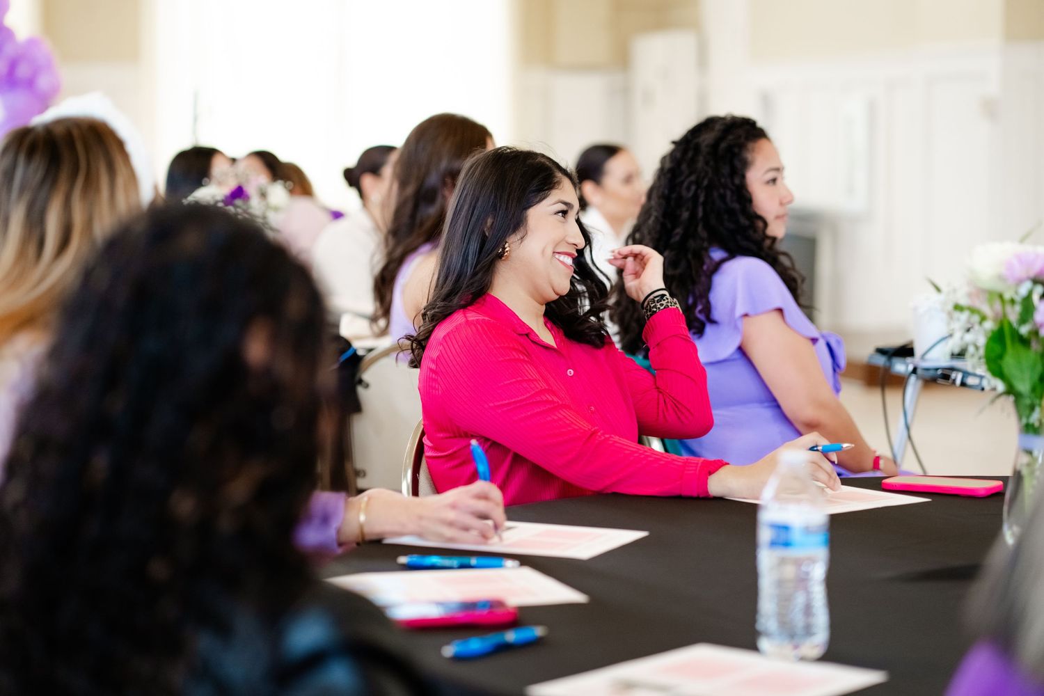 Professional conference attendees seated at tables during indoor business meeting.