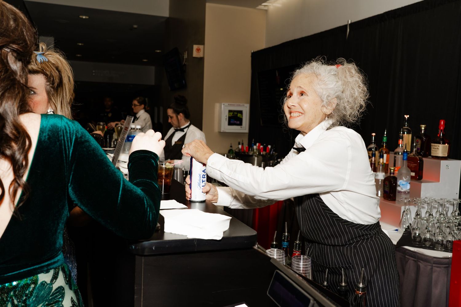 Event attendees gathered around a bar area with ambient lighting.