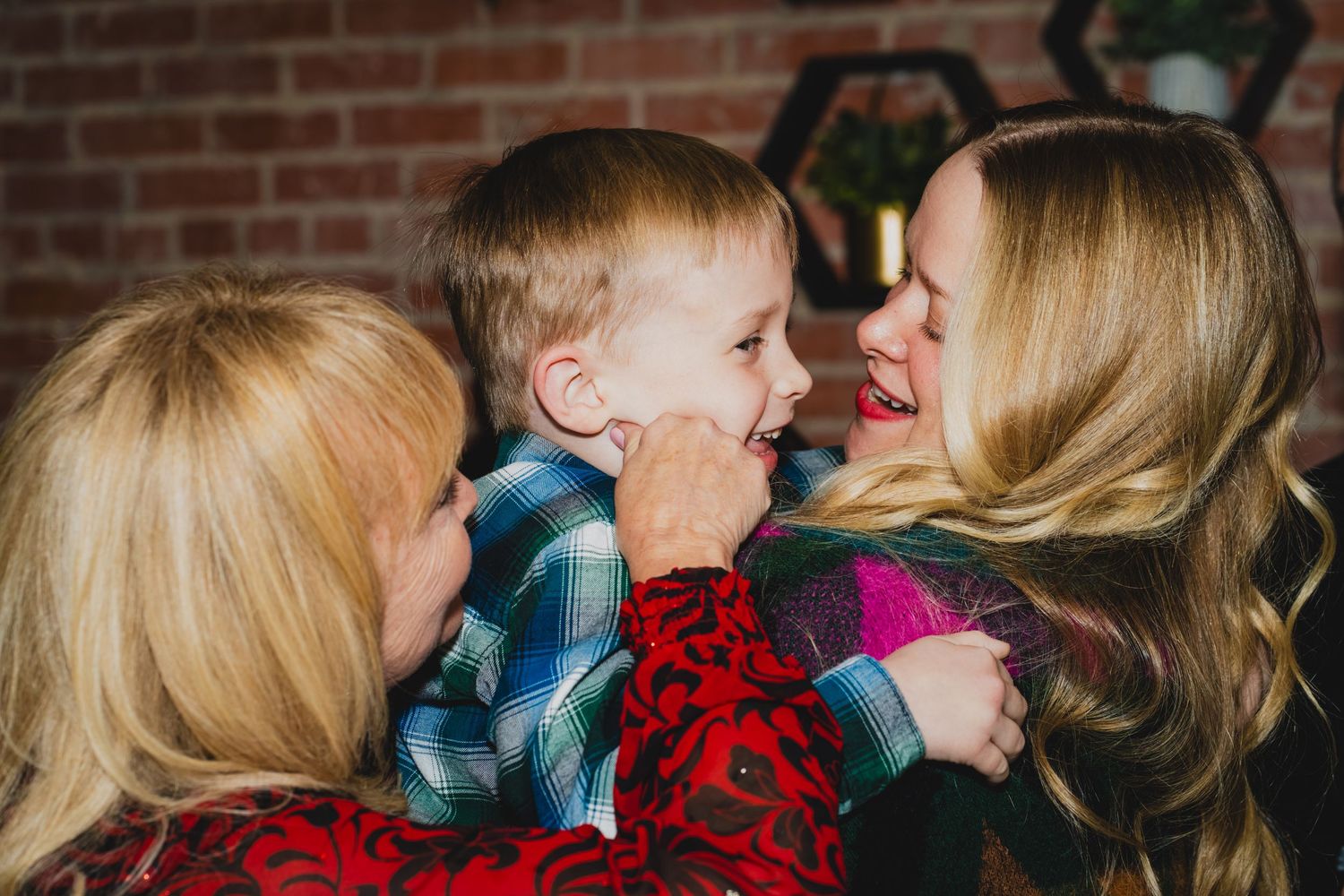 Guests mingle and socialize at a festive holiday party with a brick wall backdrop.