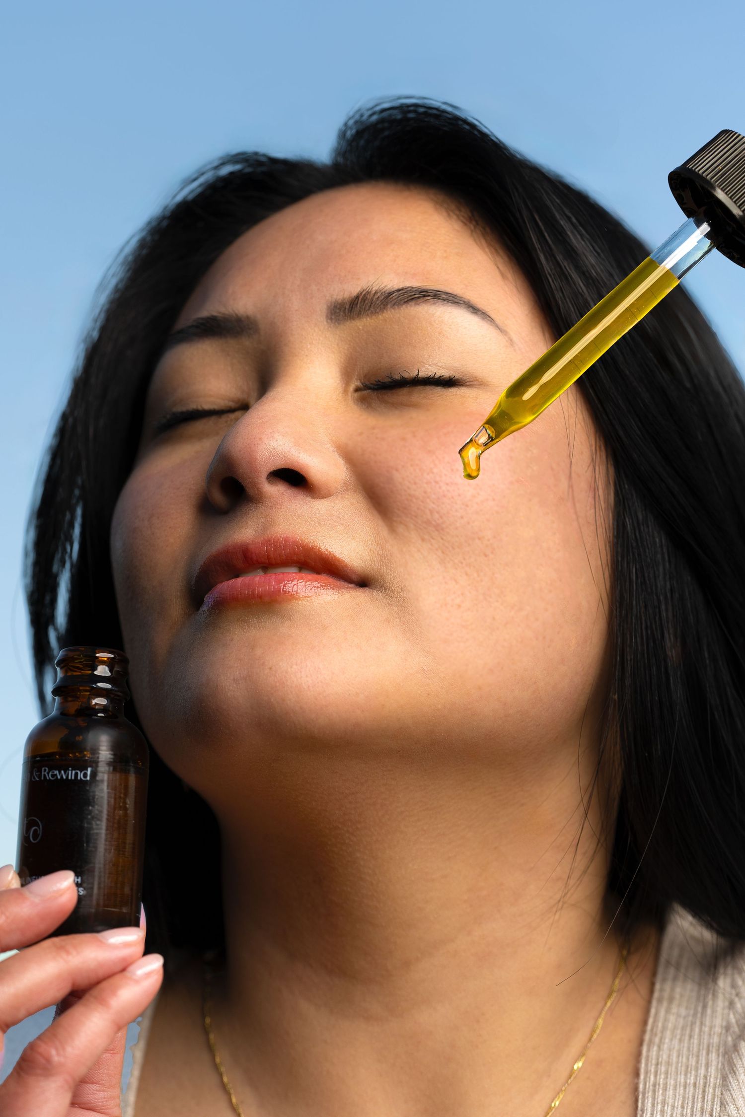 Close-up sequence showing facial oil being applied with dropper in beauty routine.