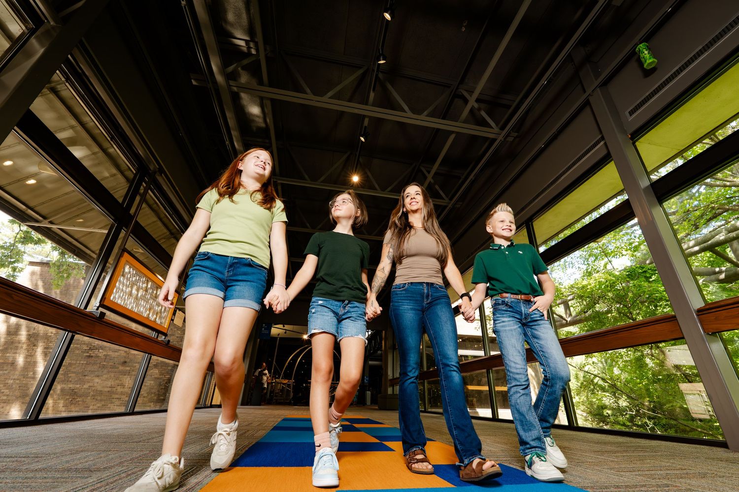 Low angle view of people walking under an industrial-style covered walkway.