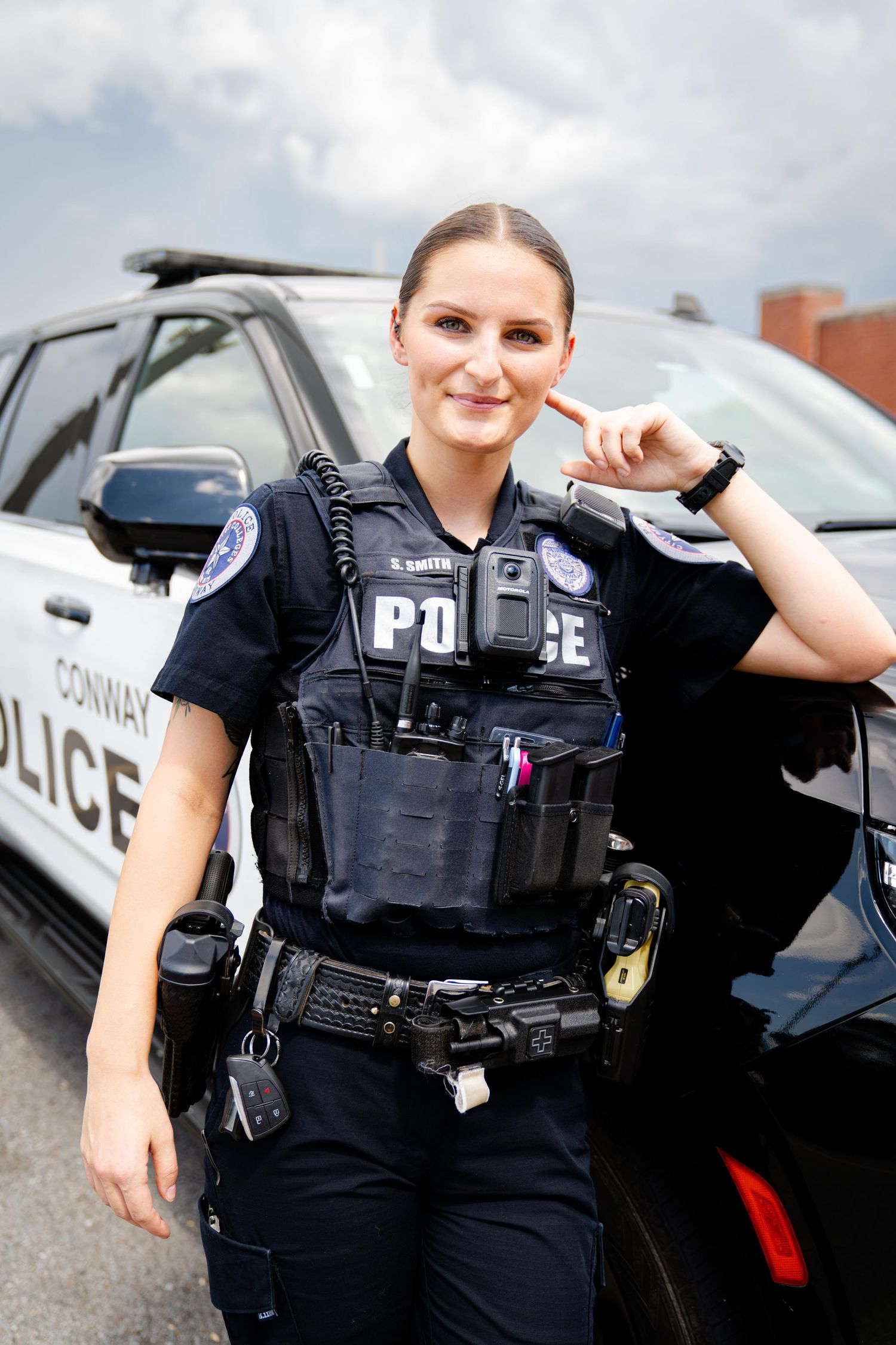Police officers in tactical gear standing next to patrol vehicles.