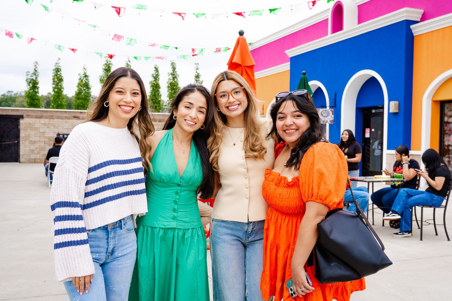 Festive outdoor celebration with Mexican-inspired decor and colorful building facades.