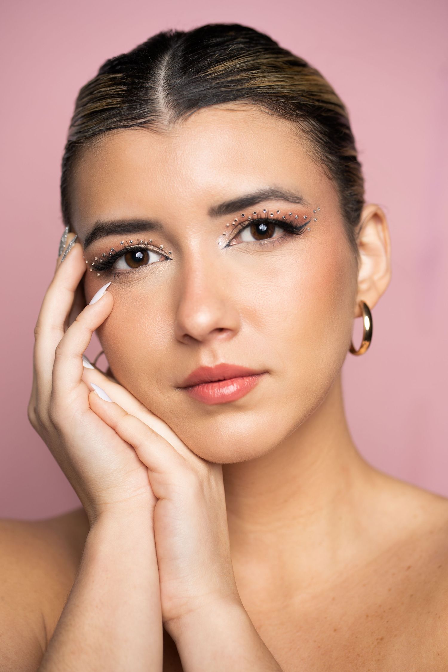 Close-up beauty shots with elegant makeup and styled hair against soft pink backdrop.