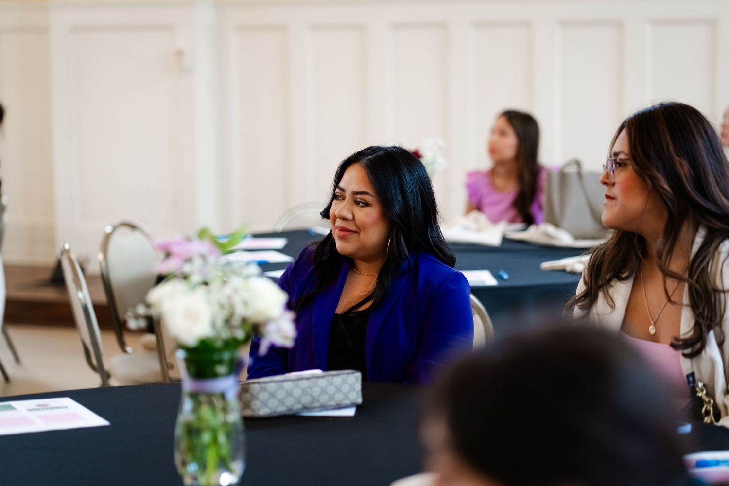 Conference attendees seated at tables during a professional development session.