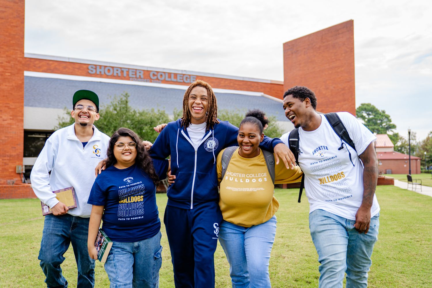Group of students walking together outside a brick building on campus.
