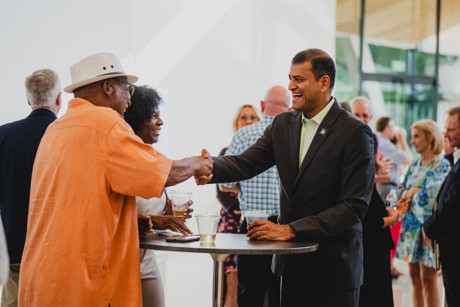 Business professionals networking and conversing at a casual reception event.