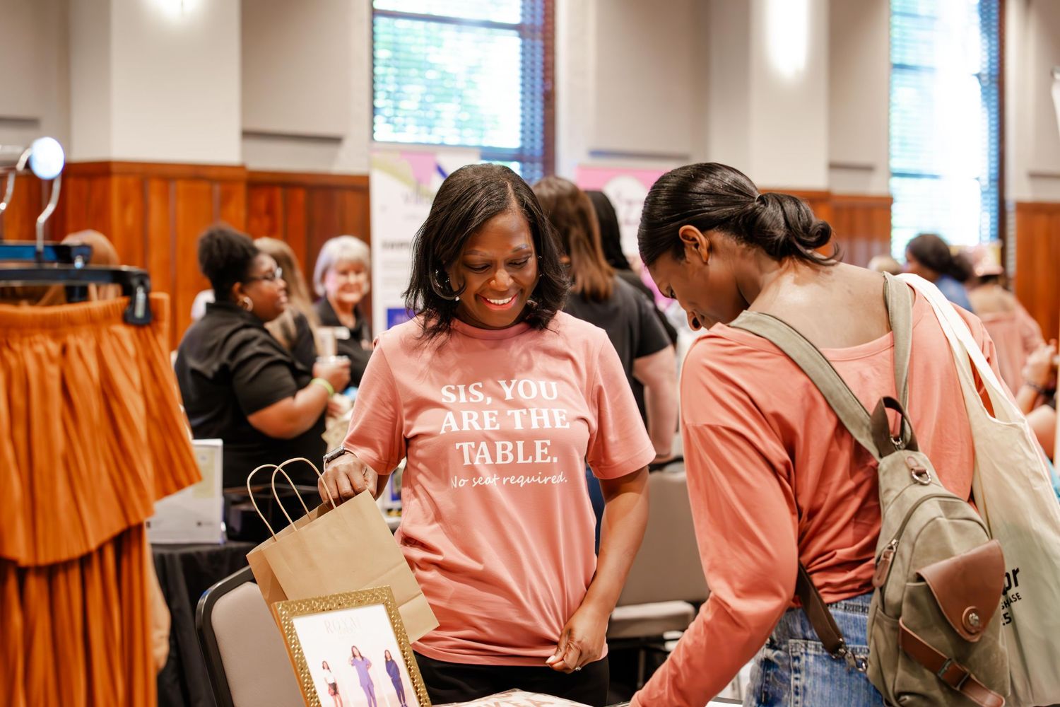 People networking and mingling at a casual indoor event with natural lighting.