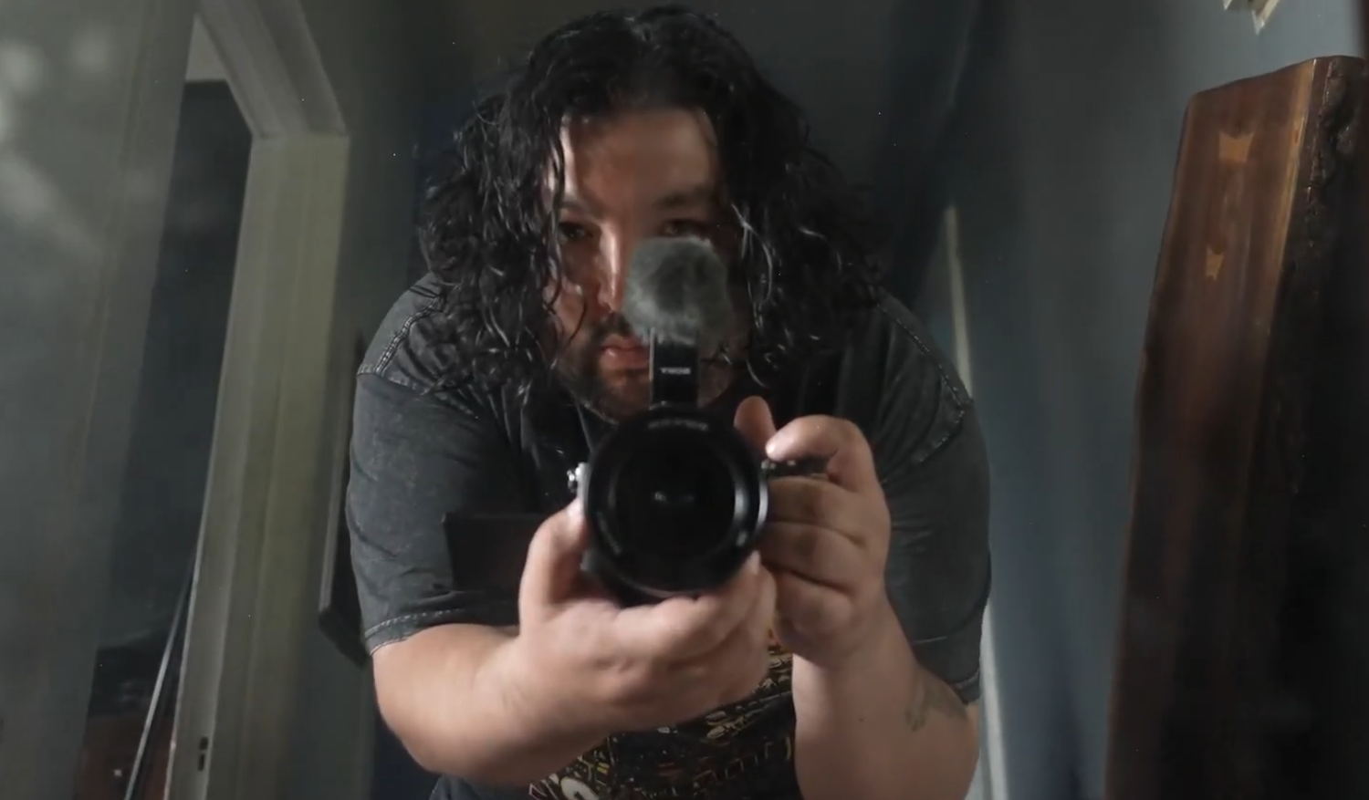 Camera equipment being adjusted in dim lighting with reflective surfaces visible. Misael nmn. Nomiddlename. Nmneither. Youtuber. Vlogger.