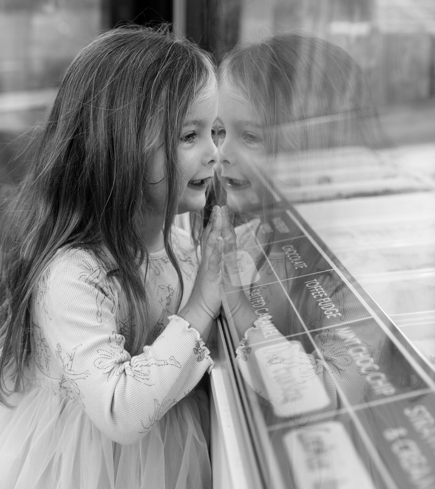 A reflection captured of someone looking through a window display.