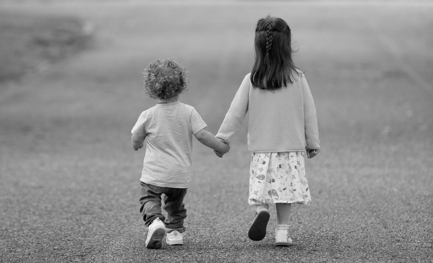 People walking together on grass in black and white photography.