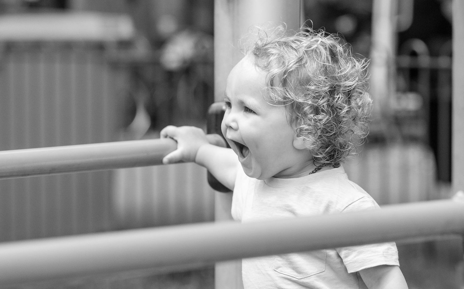 An excited expression captured at a playground in black and white.