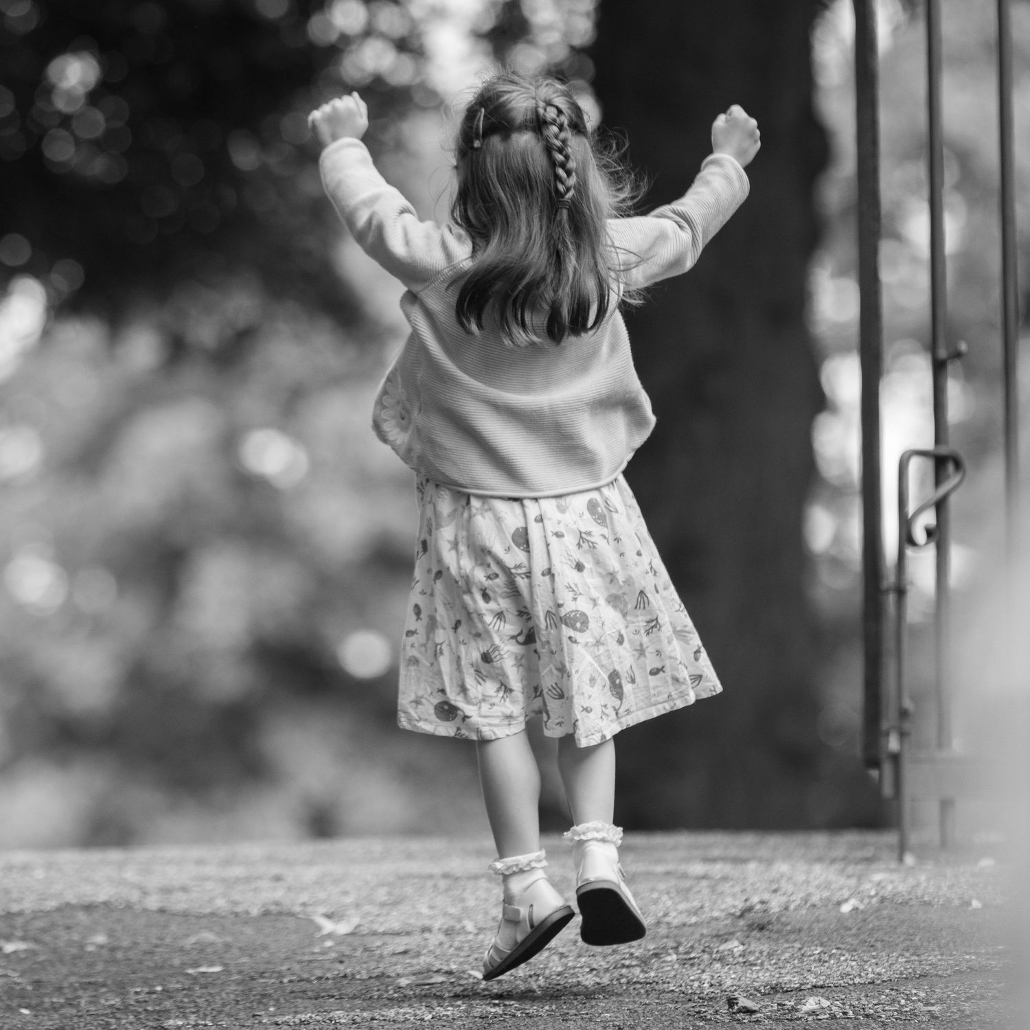 Black and white photo of small feet walking along a path.