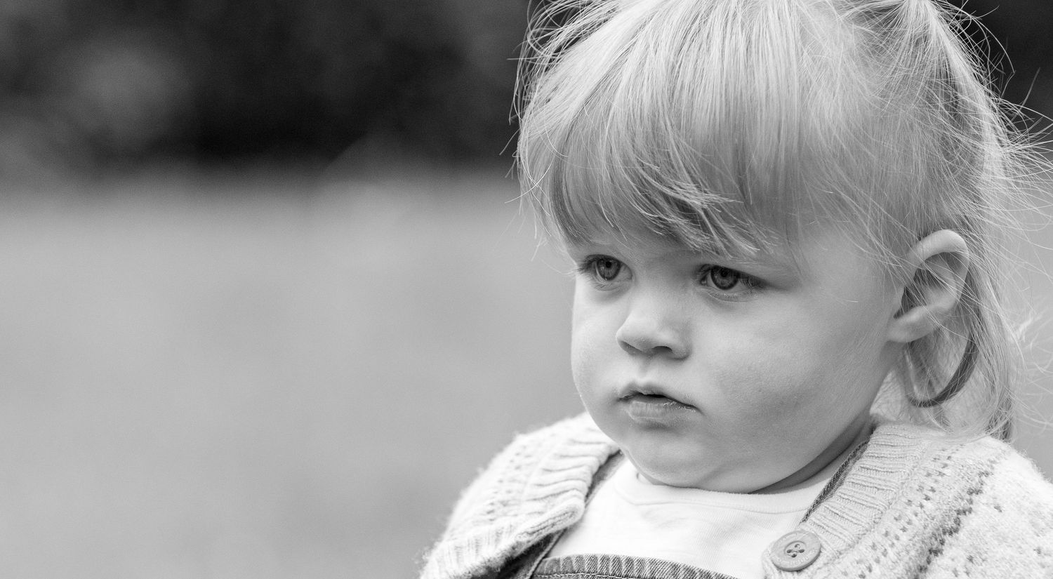 A collage of six black and white photographs showing a young child with blonde hair in different poses and expressions.